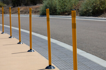 View of orange traffic guide posts on the side of the road for safety with depth of field.