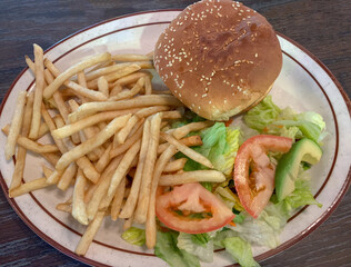 Plate with hamburger, French fries and salad.