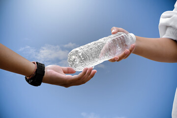 Giving plastic bottle to make recyclying, reusing and reducing objects to lower garbage and to keep...
