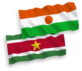 Obraz premium National vector fabric wave flags of Republic of the Niger and Republic of Suriname isolated on white background. 1 to 2 proportion.