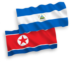 National vector fabric wave flags of North Korea and Nicaragua isolated on white background. 1 to 2 proportion.