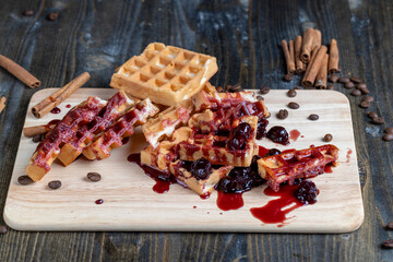 soft waffles with red cherry jam on a serving board