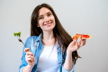 Young smiling woman chooses what to eat, pizza or salad