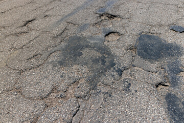 An old paved road with a lot of holes and damage