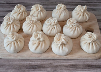 Frozen Raw dumplings Khinkali with beef and lamb meat set. Traditional Georgian raw frozen khinkali on wooden surface