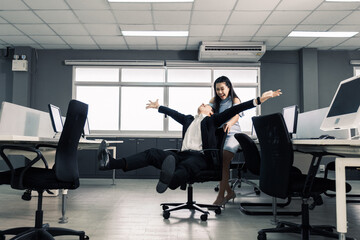 Businessman having fun and push office chair
