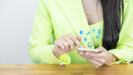 Close up Asian woman in green suit pastel holding and using smart phone, Asian woman using smartphone choosing item in marketplace on store website with virtual interface shopping online technology.