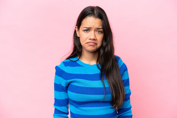 Fototapeta premium Young Colombian woman isolated on pink background with sad expression