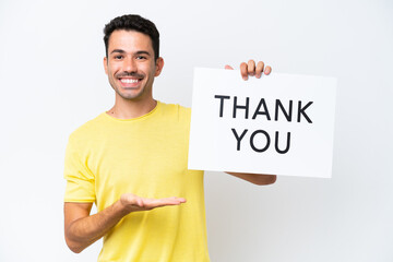 Young handsome man over isolated white background holding a placard with text THANK YOU and ...