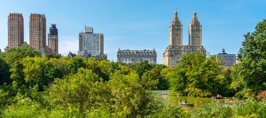 Skyline panorama with Eldorado building and reservoir with boats in Central Park in midtown Manhattan in New York City - obrazy, fototapety, plakaty