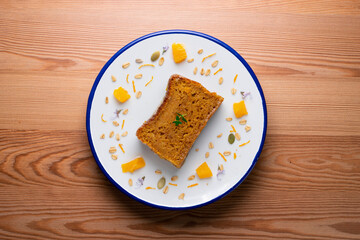 Orange sponge cake seen from above decorated with a few slices of fruit.