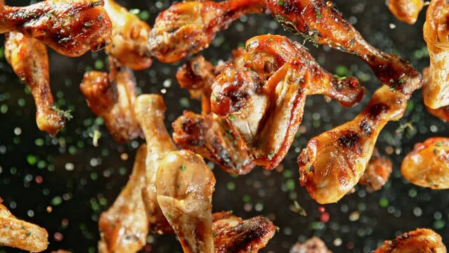Super Slow Motion Shot of Grilled Chicken Wings and Drumsticks Flying Towards Camera at 1000fps.