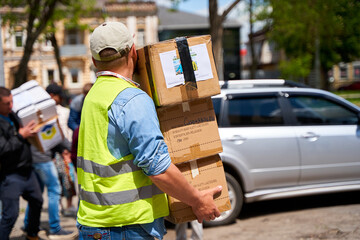 Ukrainian volunteers unloading boxes with humanitarian aid - Powered by Adobe