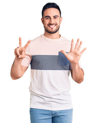 Young handsome man wearing casual clothes showing and pointing up with fingers number seven while smiling confident and happy.