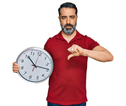 Middle aged man with beard holding big clock with angry face, negative sign showing dislike with thumbs down, rejection concept
