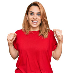 Hispanic young woman wearing casual red t shirt celebrating surprised and amazed for success with arms raised and open eyes. winner concept.