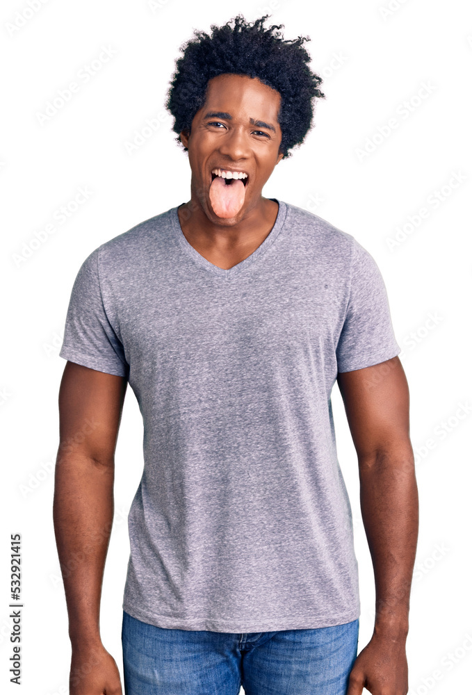 Wall mural handsome african american man with afro hair wearing casual clothes sticking tongue out happy with f