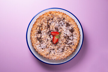 Almond cake with chocolate and decorated with a strawberry in the center.
