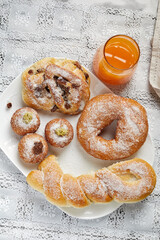 Brioche of various shapes and sizes, with sugar and orange juice
