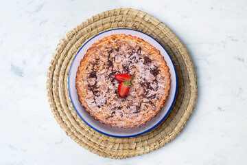 Almond cake with chocolate and decorated with a strawberry in the center.