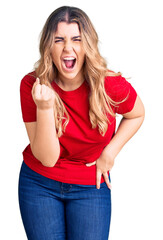 Young caucasian woman wearing casual clothes angry and mad raising fist frustrated and furious...