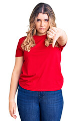 Young caucasian woman wearing casual clothes looking unhappy and angry showing rejection and negative with thumbs down gesture. bad expression.