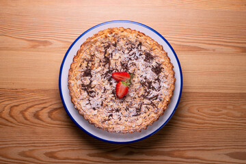 Almond cake with chocolate and decorated with a strawberry in the center.