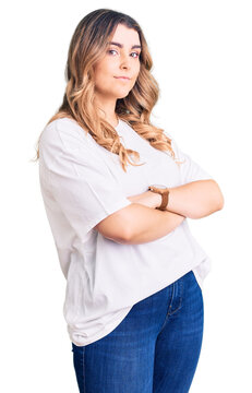 Young caucasian woman wearing casual clothes looking to the side with arms crossed convinced and confident