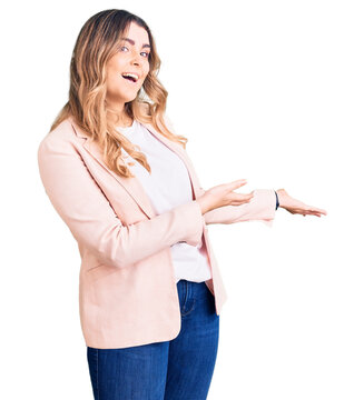 Young caucasian woman wearing business clothes inviting to enter smiling natural with open hand