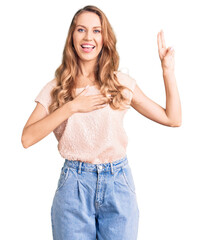 Young beautiful caucasian woman with blond hair wearing casual clothes smiling swearing with hand on chest and fingers up, making a loyalty promise oath