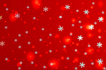 Obraz na płótnie Canvas Beautiful Christmas red background with falling white snowflakes and fabulous highlights. The concept of New Year and Christmas cards and backgrounds.