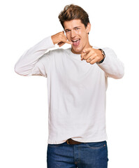 Handsome caucasian man wearing casual white sweater smiling doing talking on the telephone gesture...