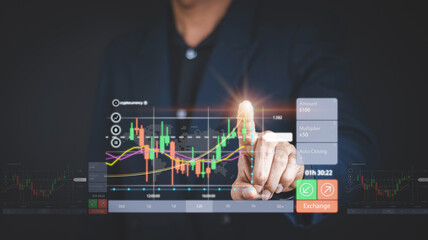 Businessman or trader is pointing a growing virtual hologram stock, planning analyze indicator and strategy buy and sell, Stock market, Business growth, progress or success concept.nvest in trading