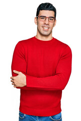 Handsome hispanic man wearing casual clothes and glasses happy face smiling with crossed arms...