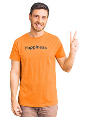 Handsome young man with bear wearing tshirt with happiness word message smiling looking to the...