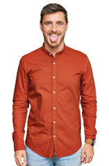 Handsome caucasian man wearing casual clothes sticking tongue out happy with funny expression. emotion concept.