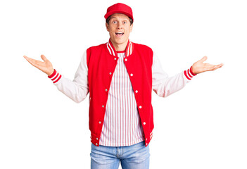 Young handsome man wearing baseball uniform celebrating victory with happy smile and winner expression with raised hands