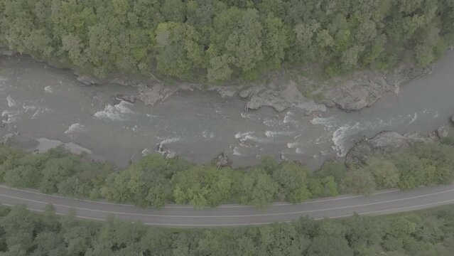 Aerial view of Mountain river and road. Flying over a mountain gorge. ProRes 422, 10 bit ungraded DJI D-LOG video