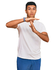 Young arab man wearing casual clothes doing time out gesture with hands, frustrated and serious face
