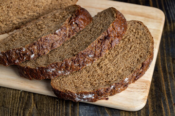 Sliced black rye bread on a board