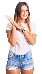 Beautiful caucasian woman wearing casual white tshirt clapping and applauding happy and joyful,...