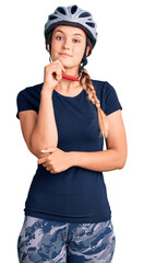 Beautiful caucasian woman wearing bike helmet looking confident at the camera with smile with crossed arms and hand raised on chin. thinking positive.