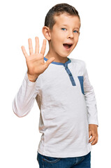 Adorable caucasian kid wearing casual clothes showing and pointing up with fingers number five while smiling confident and happy.