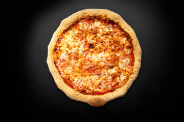 Homemade pizza with cheese on a dark background.