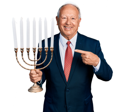 Senior business man with grey hair holding menorah hanukkah jewish candle smiling happy pointing with hand and finger