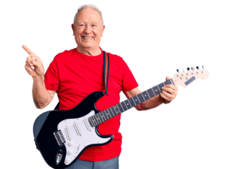 Senior handsome grey-haired man playing electric guitar smiling happy pointing with hand and finger to the side