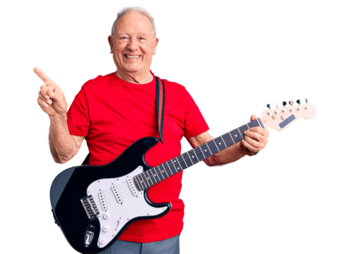 Senior handsome grey-haired man playing electric guitar smiling happy pointing with hand and finger to the side