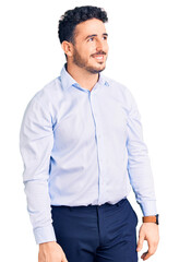 Young hispanic man wearing business clothes looking away to side with smile on face, natural expression. laughing confident.