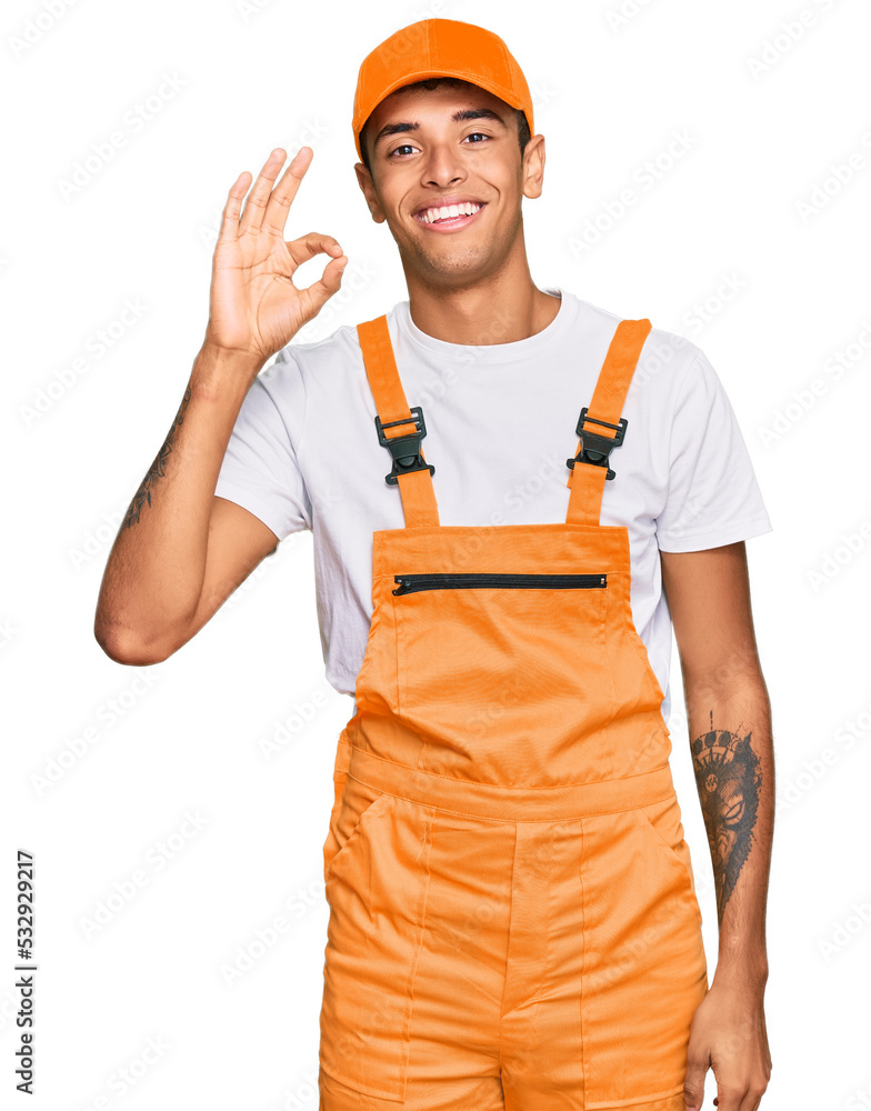 Sticker young handsome african american man wearing handyman uniform smiling positive doing ok sign with han