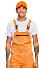 Young handsome african american man wearing handyman uniform with a happy and cool smile on face. lucky person.